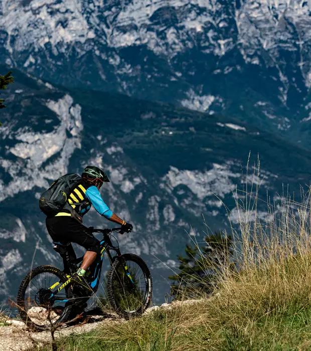 ebike-in-montagna Cycling, mountain biker couple on cycle trail in autumn forest. Mountain biking in autumn landscape forest. Man and woman cycling MTB flow uphill trail.